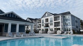 Morehead City apartment for rent - A large swimming pool in front of a multi-story residential building.