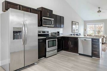 Greenville townhouse for rent - A modern kitchen with a stainless steel refrigerator and black cabinets.