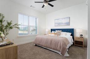 Wilmington apartment for rent - A bedroom with a bed, nightstand, and a plant.