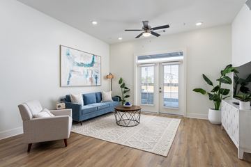 Wilmington apartment for rent - A living room with a blue couch, a chair, a coffee table, and a painting on the wall.
