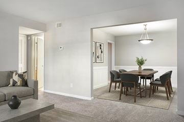 Savannah apartment for rent - A modern living room with a grey couch and a grey dining table with six chairs.