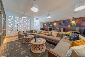 Durham apartment for rent - A living room with a grey couch and a large painting on the wall.