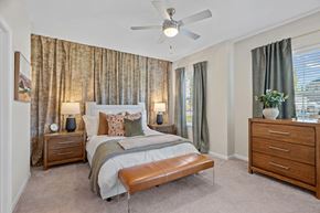 Greensboro apartment for rent - A bedroom with a bed, nightstands, and a ceiling fan.