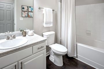 Kennesaw apartment for rent - A white toilet sits next to a sink in a bathroom.