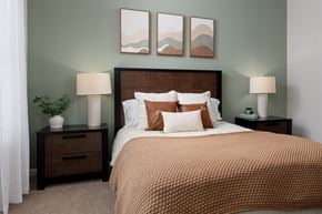 Leland apartment for rent - A bedroom with a large bed and two nightstands with lamps.