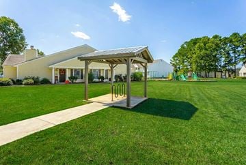 Huntsville apartment for rent - A playground with a swing set and a pavilion in the background.