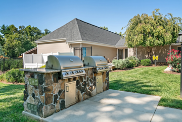Asheville apartment for rent - A stone BBQ grill is in front of a house.