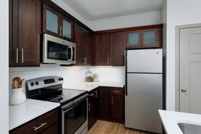 Wilmington apartment for rent - A kitchen with dark wood cabinets and stainless steel appliances.