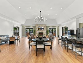 Ooltewah apartment for rent - A modern dining room with a stone fireplace and a large table set for six.