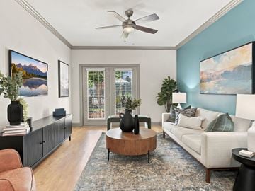 Ooltewah apartment for rent - A living room with a ceiling fan, a sofa, a coffee table, and a painting on the wall.