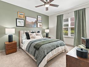 Ooltewah apartment for rent - A bedroom with a bed, nightstand, and a ceiling fan.