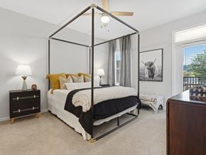 Chattanooga apartment for rent - A bedroom with a four poster bed and a painting of a cow on the wall.