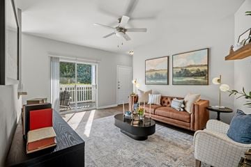 Greensboro apartment for rent - A living room with a brown couch, a coffee table, and a painting on the wall.