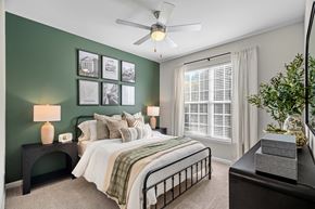 Greensboro apartment for rent - A bedroom with a bed, nightstand, and a ceiling fan.