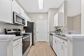 Greensboro apartment for rent - A kitchen with white cabinets and a black refrigerator.