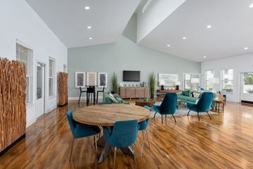 Wilmington apartment for rent - A modern living room with a wooden table and blue chairs.