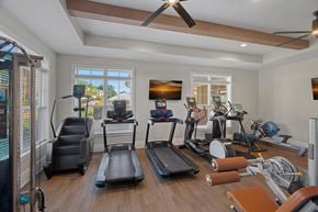 Mooresville apartment for rent - A spacious home gym with treadmills, elliptical machines, and other exercise equipment.
