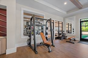 Mooresville apartment for rent - A gym with a variety of equipment including a squat rack and a bench.