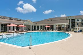 Ocean Isle Beach apartment for rent - A large swimming pool with a diving board in the middle of it.