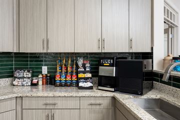 New Bern apartment for rent - A kitchen with a black microwave oven and a countertop with various food items.