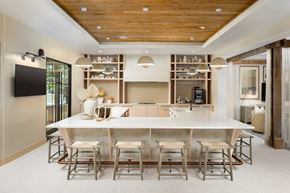 Fort Myers apartment for rent - A modern dining room with a wooden ceiling and a long table with chairs.