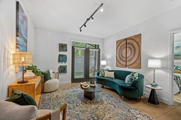 Wake Forest apartment for rent - A living room with a green couch and a rug.