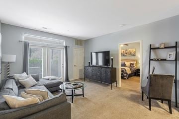 Macon apartment for rent - A living room with a grey couch and a glass coffee table.