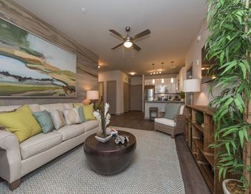 Savannah apartment for rent - A living room with a large painting on the wall and a couch with yellow pillows.