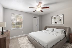 Savannah apartment for rent - A bedroom with a bed, a ceiling fan, and a window with blinds.
