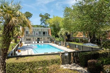 Savannah apartment for rent - A house with a pool surrounded by greenery.
