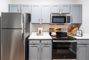 Knoxville apartment for rent - A modern kitchen with a stainless steel refrigerator and a black stove top.