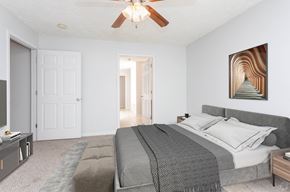 Fayetteville apartment for rent - A bedroom with a large bed and a ceiling fan.