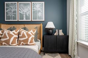 Hampstead apartment for rent - A bedroom with a bed, a nightstand with a lamp, and three framed pictures on the wall.