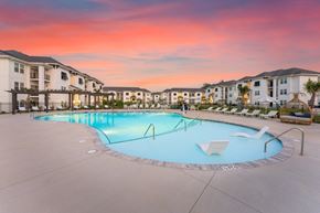 Shallotte apartment for rent - A swimming pool surrounded by lounge chairs and buildings in the background at Monument at Ocean and Main in Shallotte, NC..