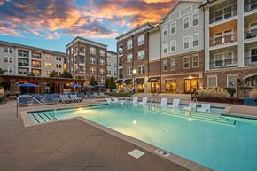 Cornelius apartment for rent - A swimming pool surrounded by lounge chairs and buildings in the background.
