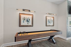 Fayetteville apartment for rent - A pool table with a wooden frame and a light brown cloth is in the center of the room.