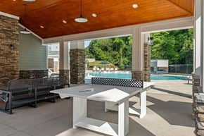 Wake Forest apartment for rent - a patio with a ping pong table and a pool in the background