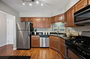 Schaumburg apartment for rent - A kitchen with wooden cabinets and a black stove top oven.