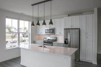 A kitchen with white cabinets and a white counter top