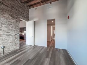 Chicago townhouse for rent - A room with a wooden floor and a brick wall.