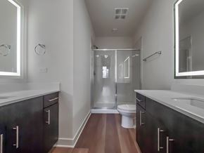 Chicago townhouse for rent - A modern bathroom with a walk-in shower and a toilet.