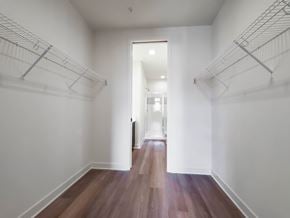 Chicago townhouse for rent - A hallway with white walls and wood flooring leading to a door.