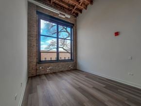 Chicago townhouse for rent - A room with a large window and wooden flooring.