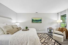 Palatine apartment for rent - A bedroom with a large bed and a painting on the wall.