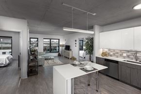 Chicago apartment for rent - a kitchen and living room with a white island in the middle at Residences at Addison Clark Apartments, Chicago, 60613