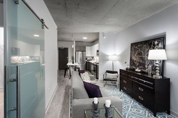 Chicago apartment for rent - A modern living room with a grey couch and a black dresser.