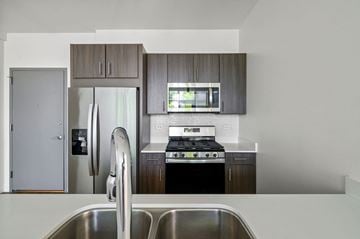 Chicago apartment for rent - A modern kitchen with a stainless steel sink and a refrigerator with a water dispenser.