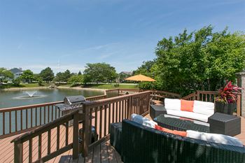 A large deck with furniture and a body of water
