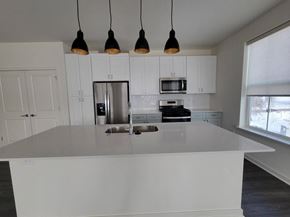 Crystal Lake townhouse for rent - A kitchen with white cabinets and a large island at Enclave Crystal Lake Townhome and Apartments