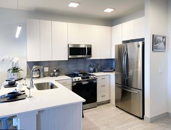 A modern kitchen with white cabinets and stainless steel appliances